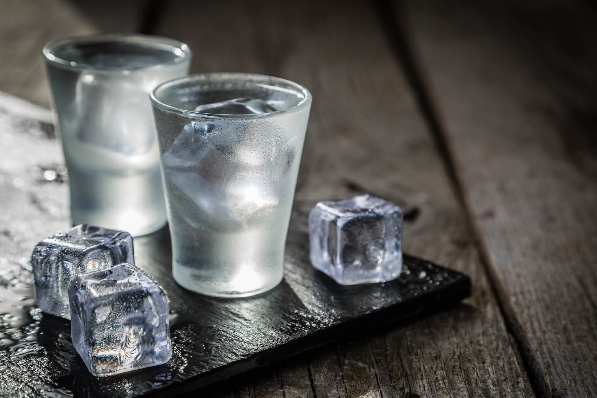 Two glasses of water with ice on table